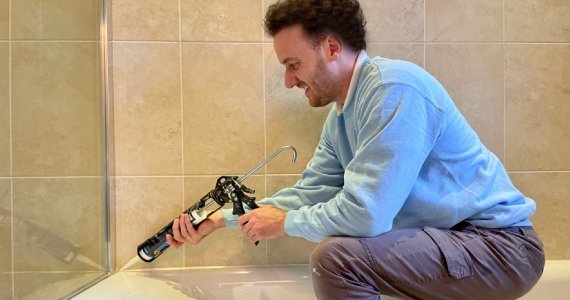 Mastic man applying silicone sealant in Wokingham kitchen